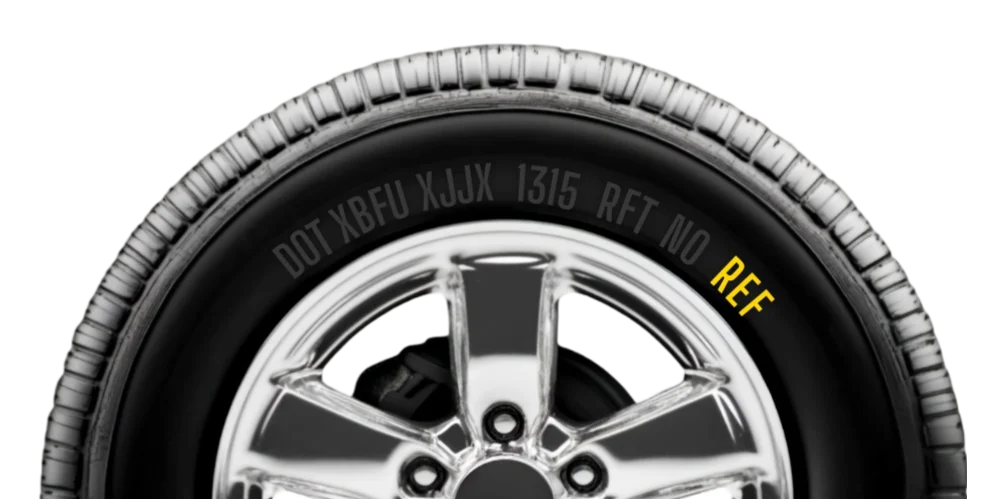 Side view of a car tyre with visible tyre size and markings on the sidewall.