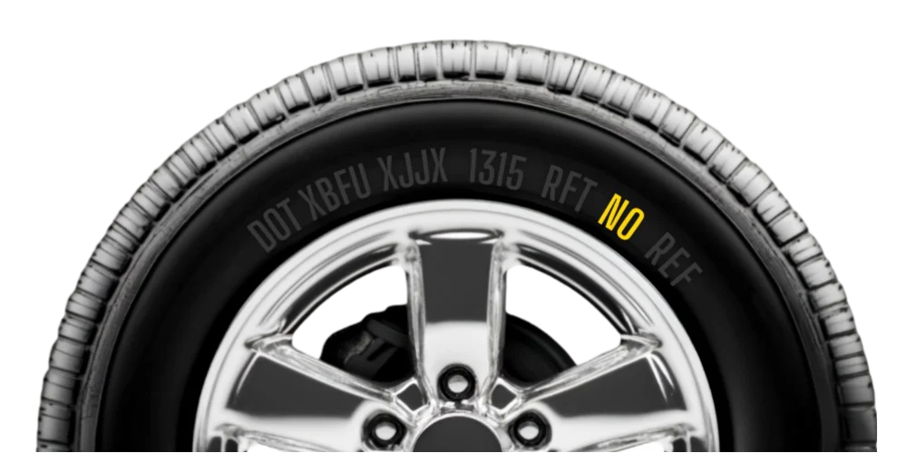 Side view of a car tyre with visible tyre size and markings on the sidewall.